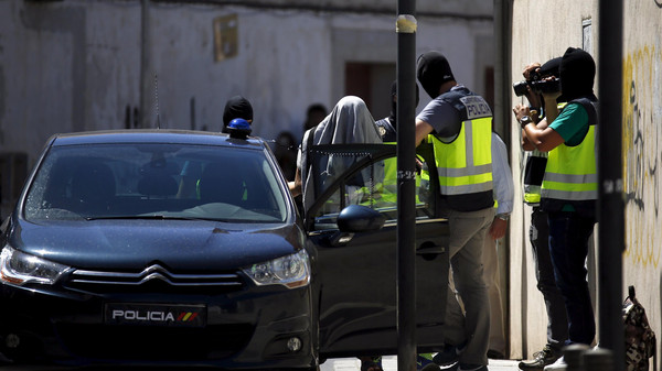 A suspect is led by Spanish National Police officers after being arrested in San Martin de la Vega