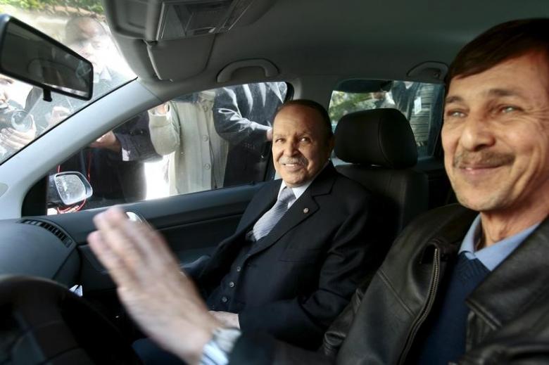 Algeria’s President Abdelaziz Bouteflika smiles as he arrives with his brother Said at his campaign’s communications department during a surprise visit in Algiers
