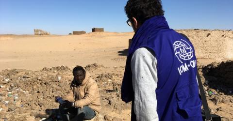 migrant being assisted by an IOM staff member in Seguedine