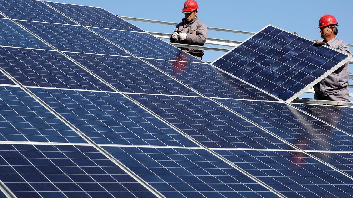 Workers-install-solar-panels-at-a-residential-home-in-a-village-in-Dongying